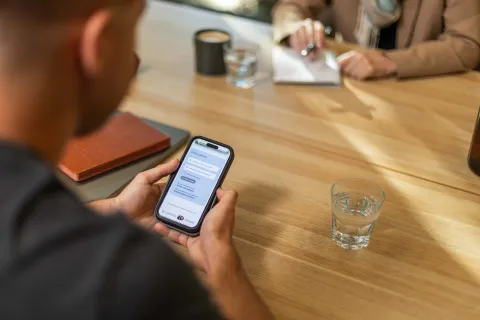 A person using a mobile phone to view the agency’s website in a community setting.