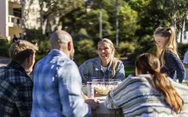 Family sitting at table outside