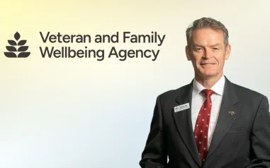 Veteran and Family Wellbeing Agency. Man in suit smiling. 