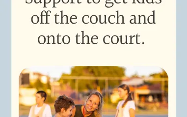 A woman smiling. Assisting a child holding a netball. 