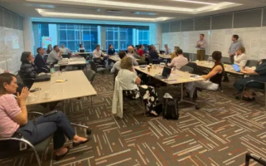 Photo of people in a office with whiteboards.