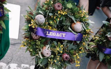 A wreath with a purple sash that says legacy.