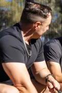 Two people sitting side by side, talking to each other in a park setting.