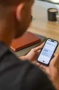 A person using a mobile phone to view the agency’s website in a community setting.