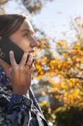 Close-up of a person in an Australian Defence Force uniform talking on a mobile phone outdoors.