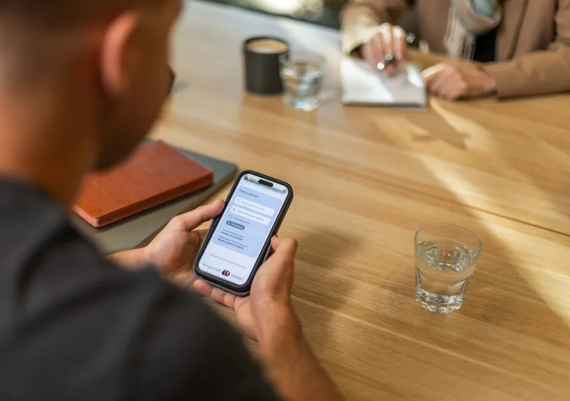 A person using a mobile phone to view the agency’s website in a community setting.