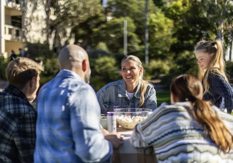 Family sitting at table outside
