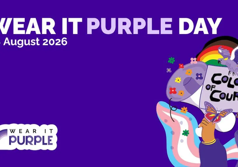 A purple background with text which says Wear It Purple Day 28 August 2026. There is a cartoon drawing of hands holding up a sign saying Colours of Courage.