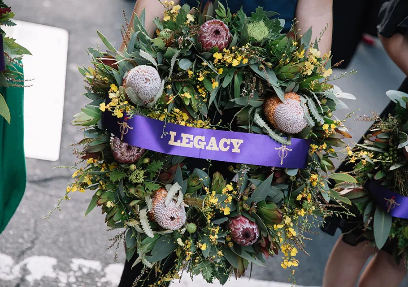 A wreath with a purple sash that says legacy.